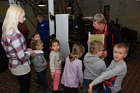 Bild: Wolfgang R&uuml;bsamen (r.) und Klaus Fahrenholz (im Hintergrund), beide vom Druckereiverein, sowie Kita-Praktikantin Kim H&ouml;hne mit "Kolumbus"-Kindern im Drucksaal an der Rotationsdruckmaschine.