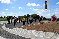 Bild: Gro&szlig;er Bahnhof zur &Uuml;bergabeveranstaltung. Die zur H&auml;lfte asphaltierte Insel des neuen Kreisverkehrs am Th&auml;lmannschacht bietet immerhin Platz f&uuml;r viele Menschen und eine Fahne.