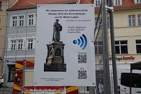 Bild: Am Bauzaun informieren Tafeln, wie man zu den angebotenen Informationen kommt.