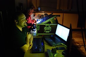 Nur im Licht ihrer Monitore und Pulte bei der Arbeit (von vorn): Norman Meyer (Videoproduktion), Hans-Heinrich St&uuml;ber (Tontechnik) und Felix Lehm (Beleuchtung).