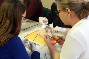 Sch&uuml;ler probieren unter Anleitung eine richtige Naht zu setzen