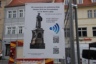 Bild: Am Bauzaun informieren Tafeln, wie man zu den angebotenen Informationen kommt.