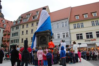Bild: Enth&uuml;llung nach der Restaurierung. Ein denkw&uuml;rdiger Augenblick, als die H&uuml;lle f&auml;llt. Die Menschen zu seinen F&uuml;&szlig;en sind fasziniert und begeistert: Luther ist zur&uuml;ck!