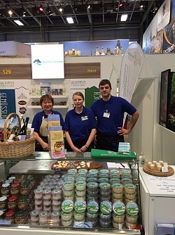 Steffi Tomljanovic, Produzentin und Direktvermarkterin von Malzit, sowie Alexandra B&ouml;ttger und Tobias Fritzsche vom Ziegenhof Pfeiffhausen am gemeinsamen Stand des Landkreises Mansfeld-S&uuml;dharz auf der Gr&uuml;nen Woche in Berlin. (Foto: Cathleen Scheiner)