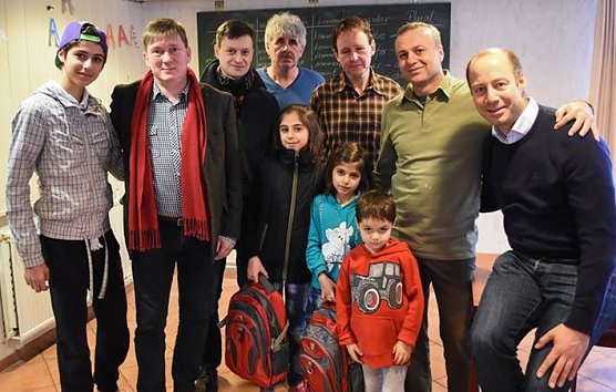 Arne Lietz (r.), Norbert Born (2. v. l.) und Mike K&uuml;nzel (3. v. l.) in der Unterkunft f&uuml;r Fl&uuml;chtlinge in Eisleben. Born und Lietz schenkten zwei M&auml;dchen, die ab Montag in Eisleben zur Schule gehen werden, je einen gef&uuml;llten Schulranzen. (Foto: Daniel Acker)