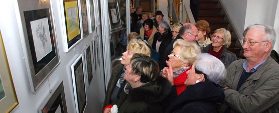 In Scharen schoben sich die Besucher an den Bilderw&auml;nden mit Werken der K&uuml;nstlerin Ramona Hollunder entlang. Da hatten es Menschen wie der Eisleber Fotok&uuml;nstler Richard Bartlitz (rechts im Bild), der die meisten Besucher um einen Kopf &uuml;berragte, leichter, einen Blick auf die Galerie zu werfen. (Foto: Jochen Miche)