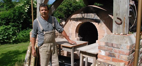 Reimar Kr&uuml;ger an dem Ofen, in dem sensationell sch&ouml;ne Keramiken in einem einw&ouml;chigen Brand entstehen. (Foto: Jochen Miche)