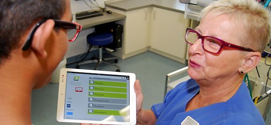 Schwester Martina sucht auf dem Tablet die Sprache aus (Foto: Helios/G. Lakomy)