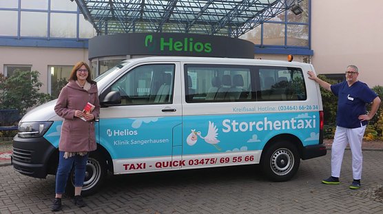 (v.l.n.r.) Antonia B&uuml;tof (Volont&auml;rin Unternehmenskommunikation und Marketing) und Dr. Olaf Parchmann (Facharzt f&uuml;r Frauenheilkunde und Geburtshilfe) neben dem Storchentaxi der Helios Klinik Sangerhausen  (Foto: Helios Kliniken Mansfeld-S&uuml;dharz, Elisa Engert)