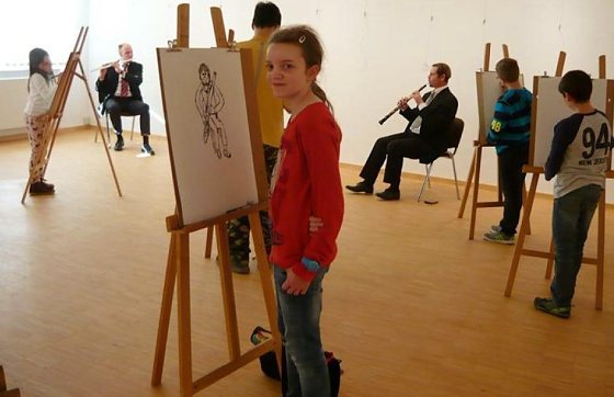 Bild: Musiker des Lohorchesters sitzen den Kindern Modell.