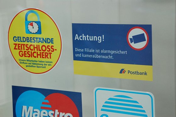 Bild: Warnungen an der T&uuml;r, welche die "richtigen" Verbrecher nicht abschrecken. Sie kommen auf verbrecherische Weise dennoch an das Geld.