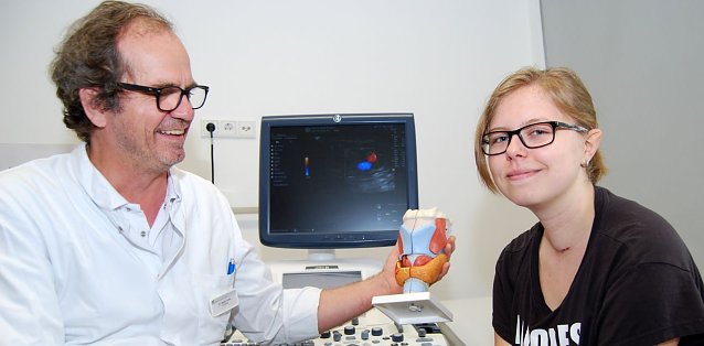 Bild: Chefarzt Dr. Kothe erkl&auml;rt Linda die Schilddr&uuml;se an einem Modell.