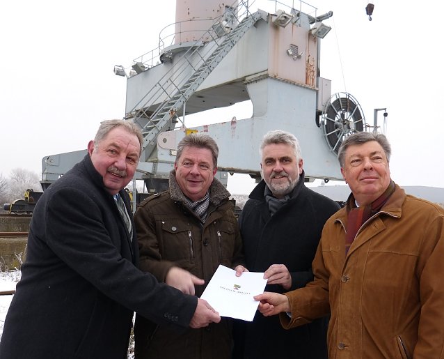 Bild: Minister Prof. Dr. Armin Willingmann (2.v.r.) und Investitionsbank-Chef Manfred Maas (l.) &uuml;berreichen die F&ouml;rderzusage an Magdeburgs Oberb&uuml;rgermeister Dr. Lutz Tr&uuml;mper und Hafen-Chef Karl-Heinz Ehrhardt (r.). Ministerium f&uuml;r Wirtschaft, Wissenschaft und Digitalisierung/