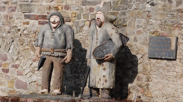 Bild: An die bis ins 13. Jahrhundert zur&uuml;ckreichende Bergbau- und H&uuml;ttentradition in Gerbstedt erinnern diese Betonfiguren eines Berghausers (links) und Schmelzers. Die Stadt erinnert sich stolz dieser Tradition. Weniger Stolz mag aufkommen beim Gedanken an die Bedingungen, unter denen die J&uuml;ngsten in ihrer Schule lernen.