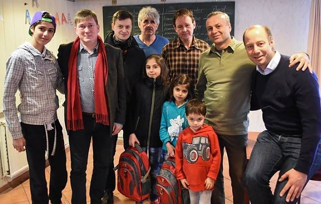 Bild: Arne Lietz (r.), Norbert Born (2. v. l.) und Mike K&uuml;nzel (3. v. l.) in der Unterkunft f&uuml;r Fl&uuml;chtlinge in Eisleben. Born und Lietz schenkten zwei M&auml;dchen, die ab Montag in Eisleben zur Schule gehen werden, je einen gef&uuml;llten Schulranzen.