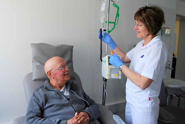 Bild: Dr. Astrid M&uuml;ller kontrolliert die Infusion bei Rainer Peters.