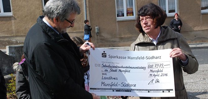 Diesen symbolischen Scheck &uuml;berreichte Landr&auml;tin Dr. Angelika Klein dem B&uuml;rgermeister der Verbandsgemeinde Mansfeld, Gustav Voigt. (Foto: Jochen Miche)