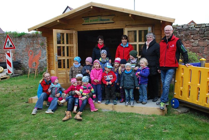 Gl&uuml;ckliche Kinder und Erwachsene vor dem "Haus der Entdecker". Im Hintergrund stehend (v.l.): Scheck&uuml;berbringerin Elfie Schubert, Kita-Leiterin Anke Rabenhold, Oberb&uuml;rgermeisterin Jutta Fischer und Ortsb&uuml;rgermeister J&uuml;rgen Grobe. (Foto: Jochen Miche)