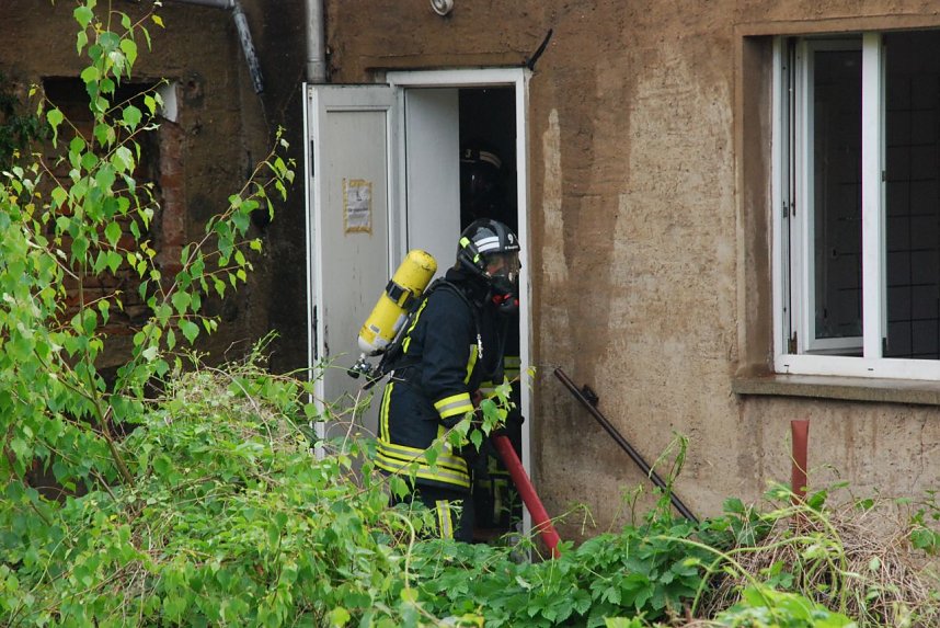 Die M&auml;nner gehen von hinten ins Haus, um von dort aus den Brand zu bek&auml;mpfen.