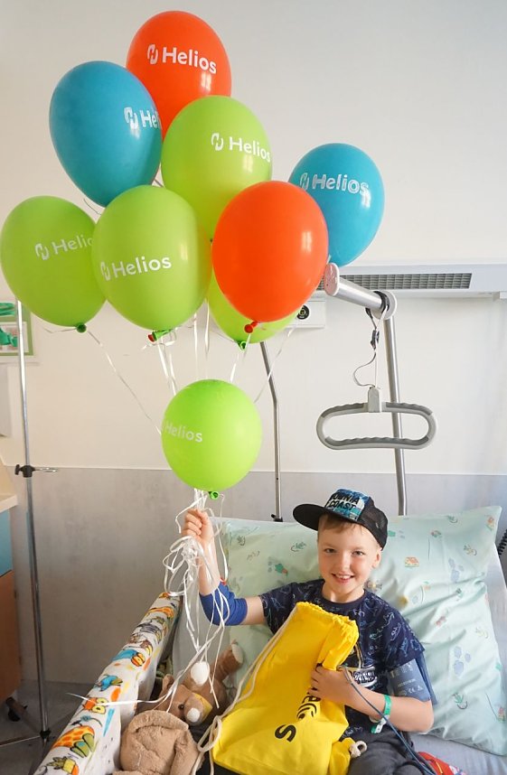 Luke freut sich &uuml;ber die Luftballons und Geschenkbeutel der Helios Klinik.  